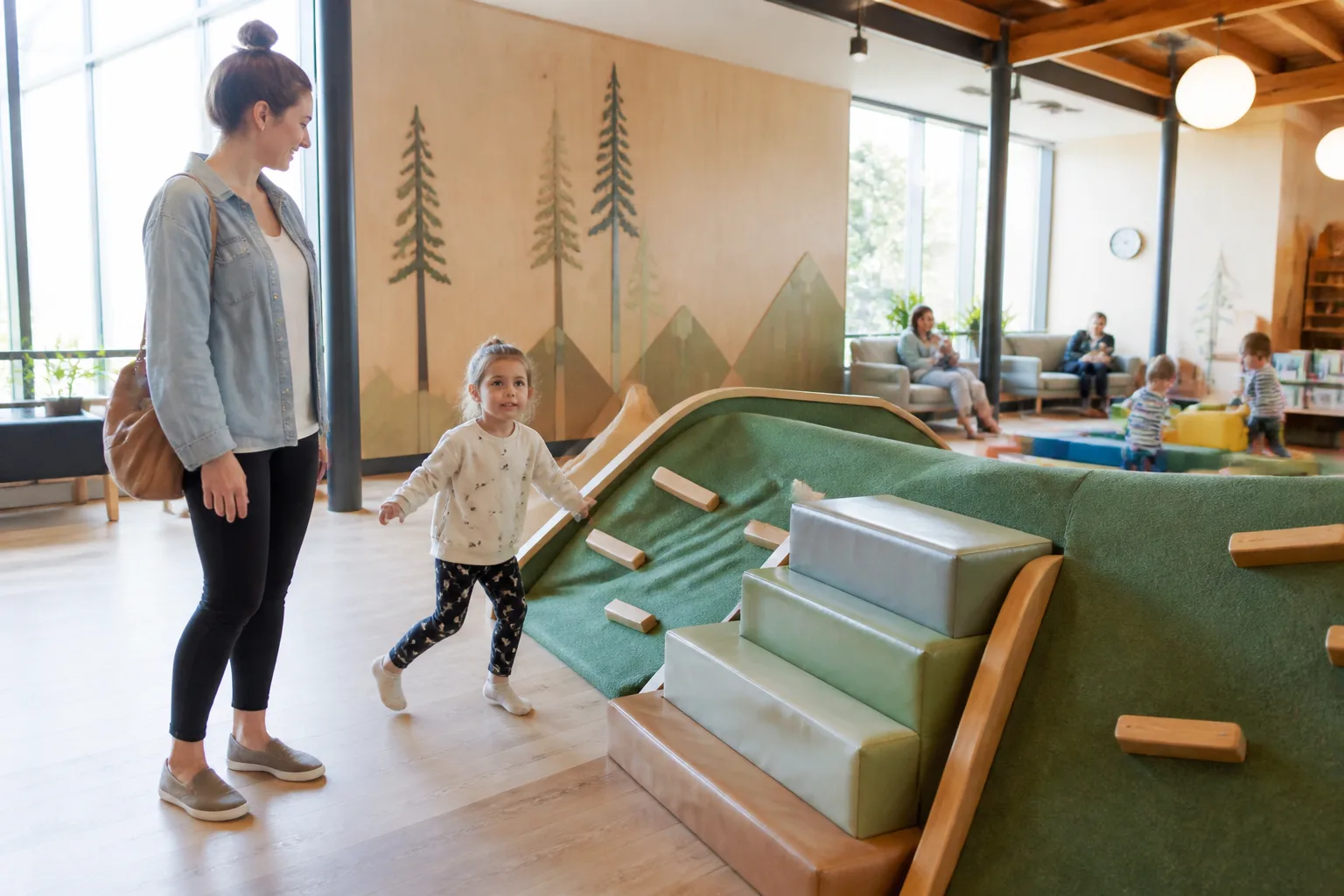 Parent and child looking into an indoor play area.