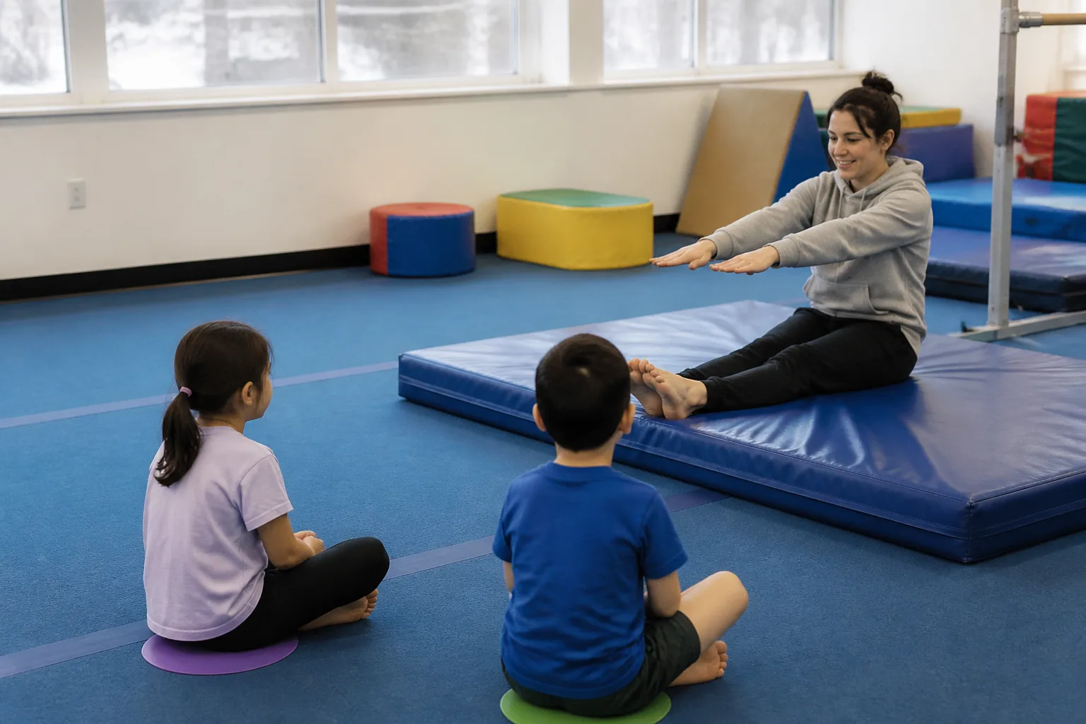 Children watching a coach demonstrate a landing position.