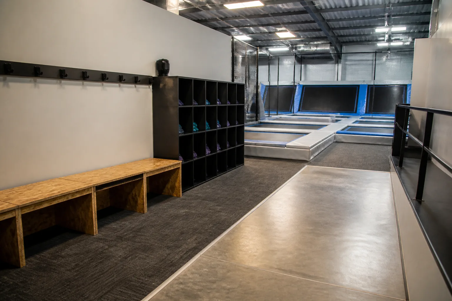 An empty trampoline park entrance opens toward several trampoline courts.